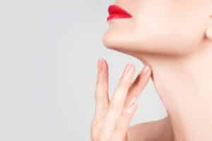 White woman displays her smooth neck after rejuvenating her lower face with cosmetic procedures.
