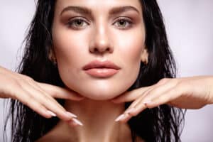 Brunette woman has luscious lips, enhanced by cosmetic procedures