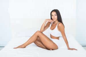 Woman in white underwear shows off her proportional thighs after cosmetic enhancement.