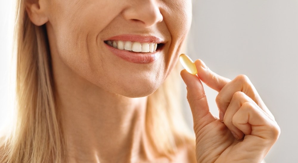 Woman takes supplement to aid with her recovery after plastic surgery.