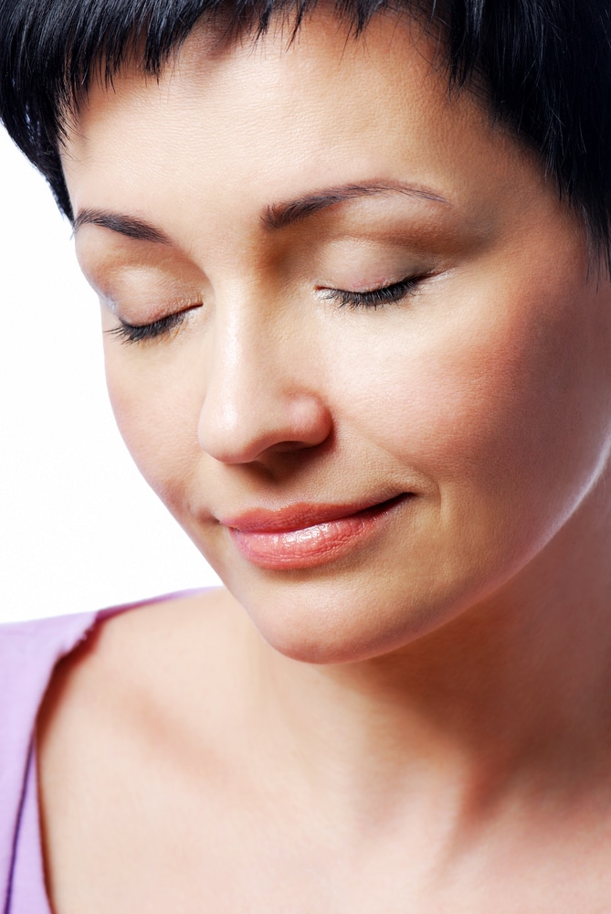 Older woman has smooth under eyes after tear trough treatment.