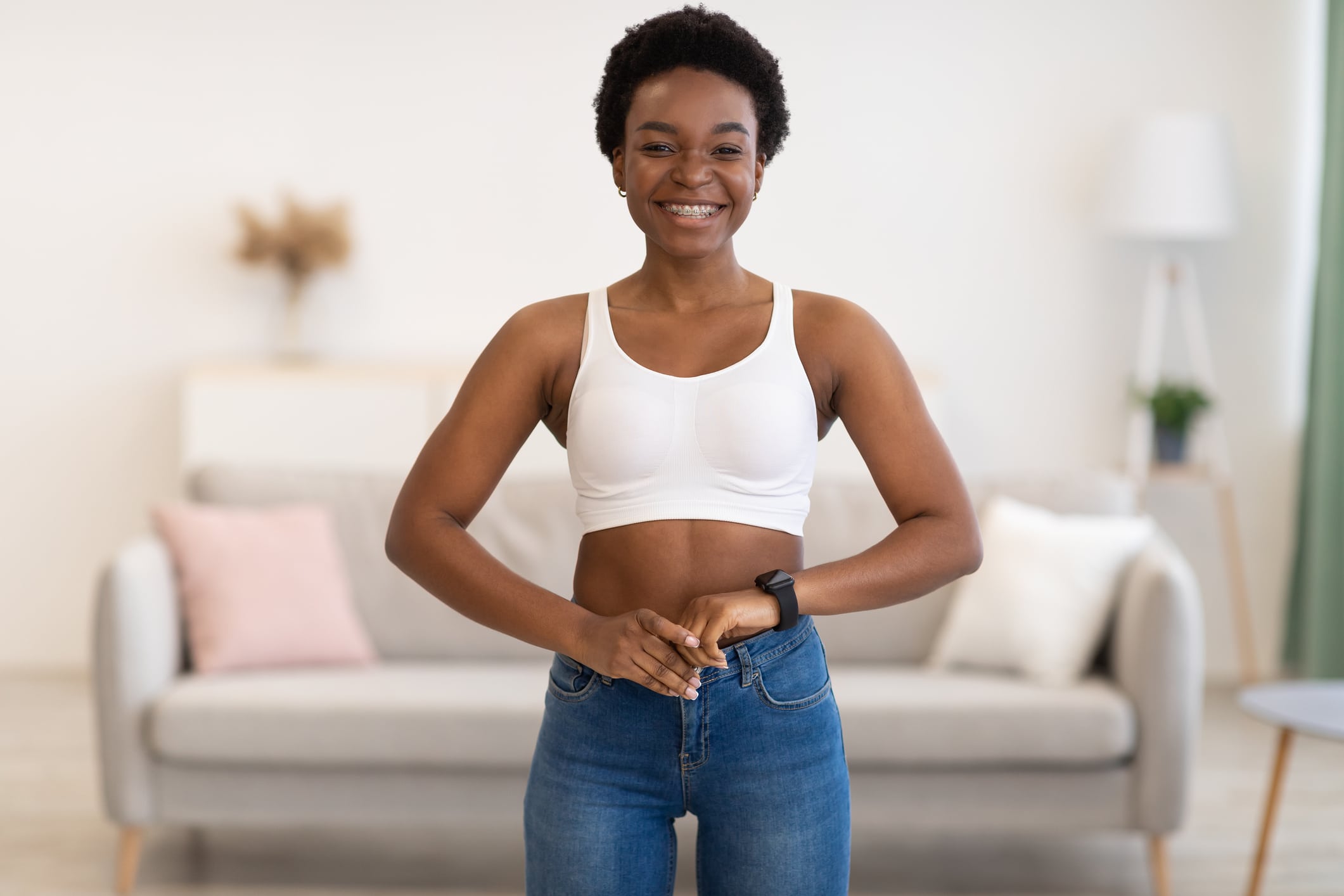 Smiling woman still fits in her skinny jeans after maintaining her weight.